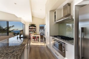 Vista desde dentro de codina moderna con estufa, horno y barra de granito