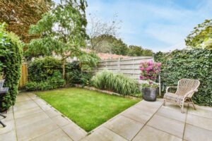 Pario trasero de casa con cerca de madera, y vegetación