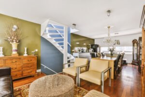 Sala abierta con escalera y cocina de fondo