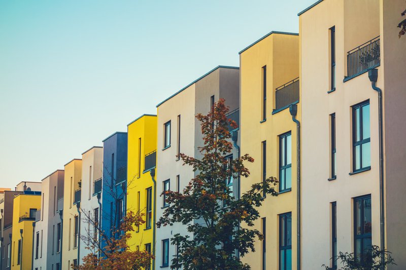 Edificios de colores con el cielo como fondo y arboles al frente